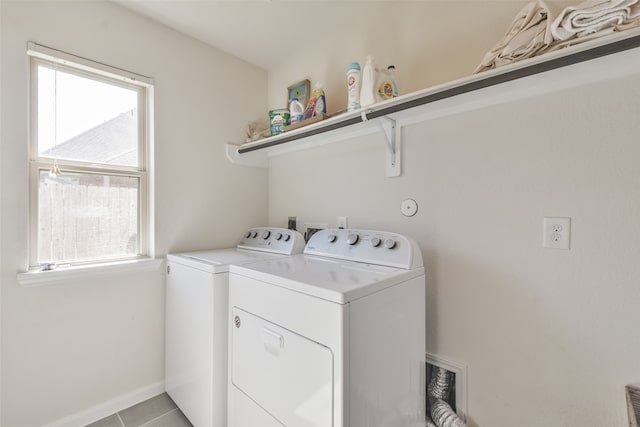 clothes washing area with washing machine and clothes dryer and light tile patterned floors