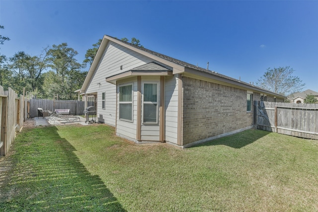 rear view of property with a yard and a patio area