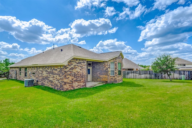 back of property with a yard and central AC unit