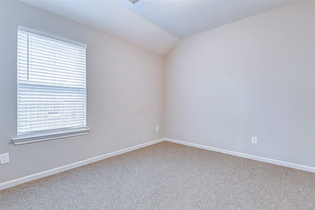 carpeted empty room featuring a healthy amount of sunlight and vaulted ceiling