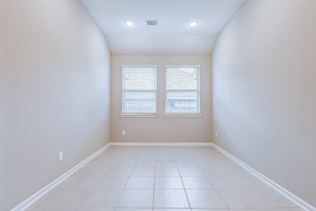 tiled spare room with vaulted ceiling