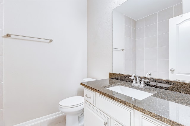 bathroom with tile patterned flooring, vanity, and toilet