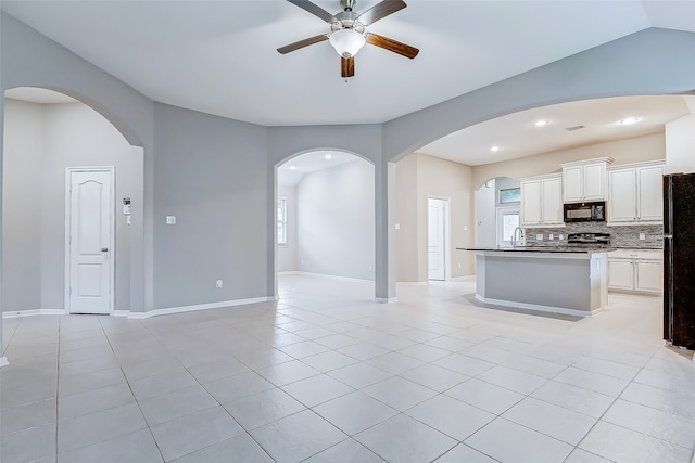 kitchen with black appliances, light tile patterned floors, white cabinetry, and a wealth of natural light