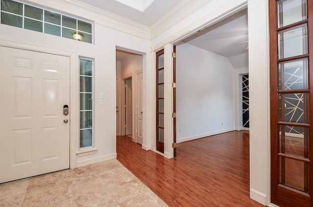 foyer entrance with ornamental molding and light hardwood / wood-style flooring