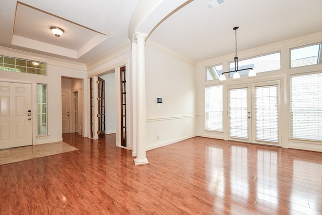 foyer with a healthy amount of sunlight, hardwood / wood-style flooring, and decorative columns