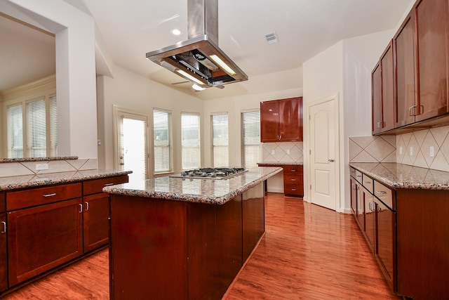 kitchen with light hardwood / wood-style flooring, light stone counters, and island exhaust hood