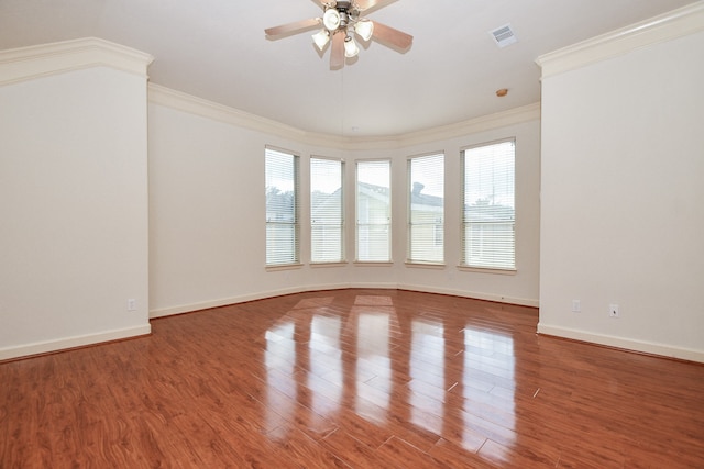 empty room featuring ceiling fan, wood-type flooring, and ornamental molding