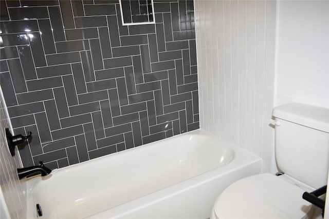 bathroom featuring toilet and tiled shower / bath