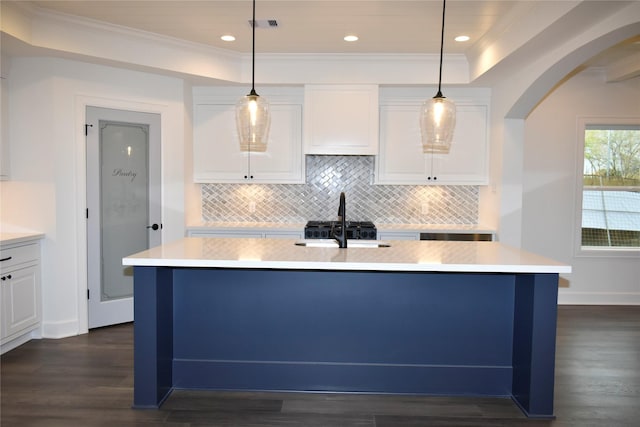 kitchen with a kitchen island with sink, pendant lighting, and dark hardwood / wood-style floors