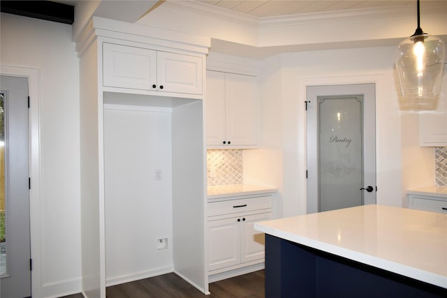 kitchen with tasteful backsplash, dark hardwood / wood-style floors, crown molding, decorative light fixtures, and white cabinets