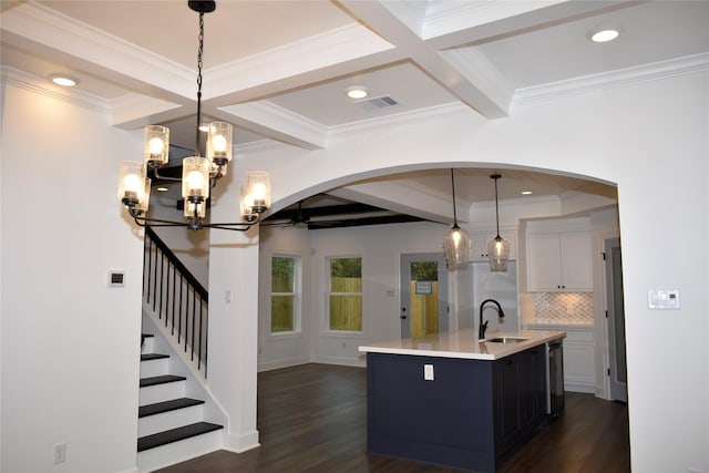 kitchen featuring a kitchen island with sink, dark hardwood / wood-style flooring, and pendant lighting