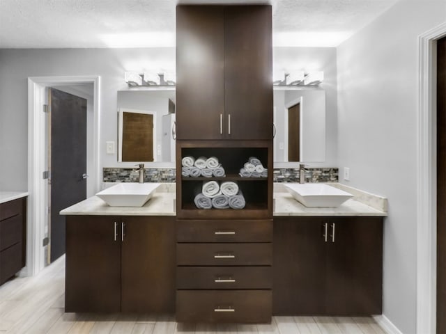 bathroom with vanity, a textured ceiling, and wood-type flooring