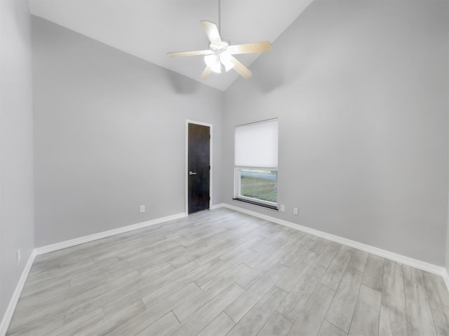 empty room featuring high vaulted ceiling, light hardwood / wood-style floors, and ceiling fan