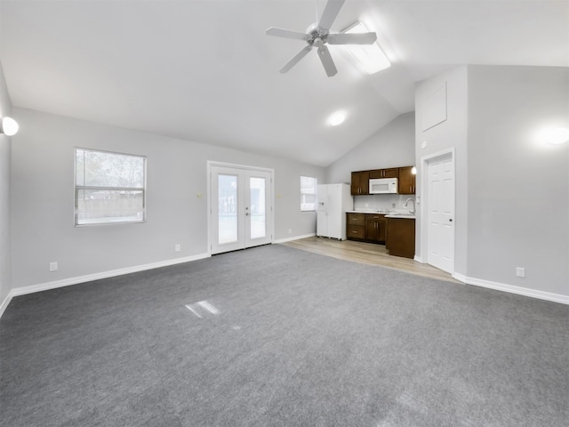 unfurnished living room with lofted ceiling, carpet, ceiling fan, french doors, and sink