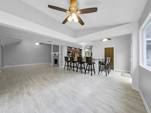 dining room with light hardwood / wood-style floors, a large fireplace, plenty of natural light, and ceiling fan