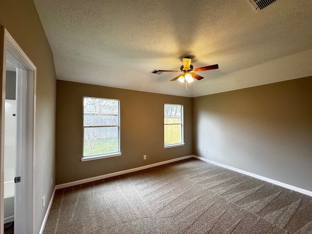 empty room with ceiling fan, a textured ceiling, and carpet floors