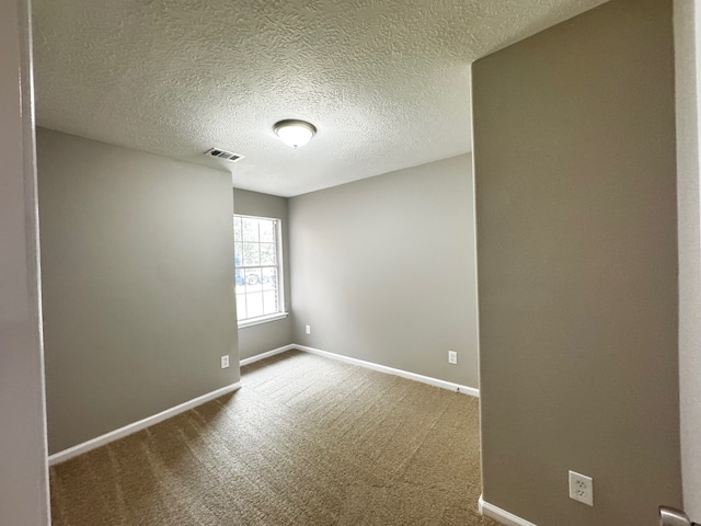 carpeted spare room featuring a textured ceiling