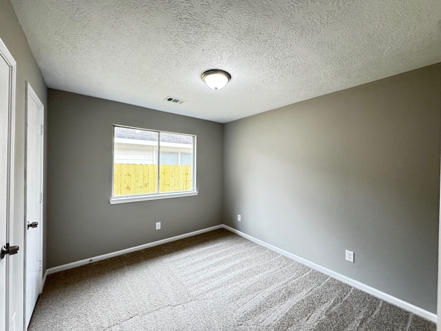 carpeted spare room featuring a textured ceiling