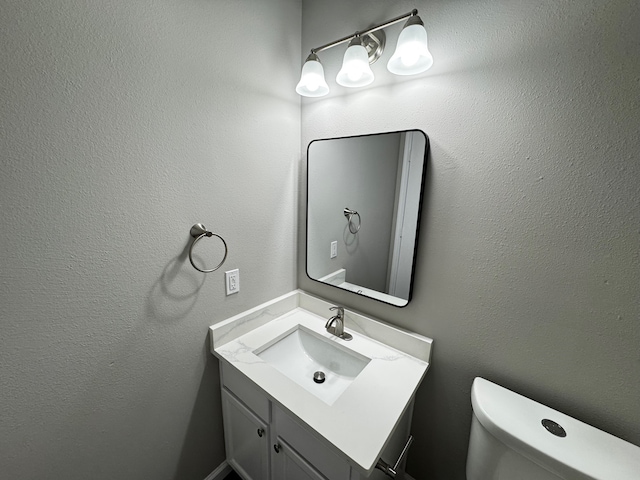 bathroom featuring toilet and vanity