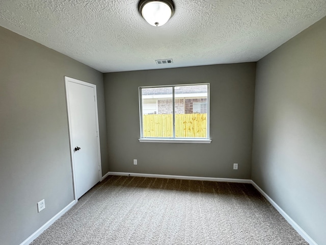 carpeted empty room with a textured ceiling