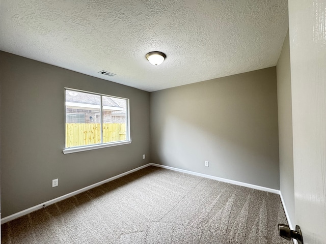 empty room with carpet and a textured ceiling