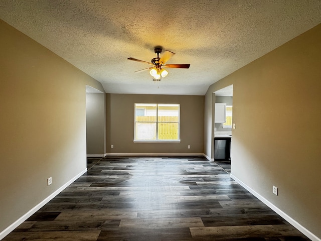 unfurnished living room featuring dark hardwood / wood-style floors, a textured ceiling, and ceiling fan