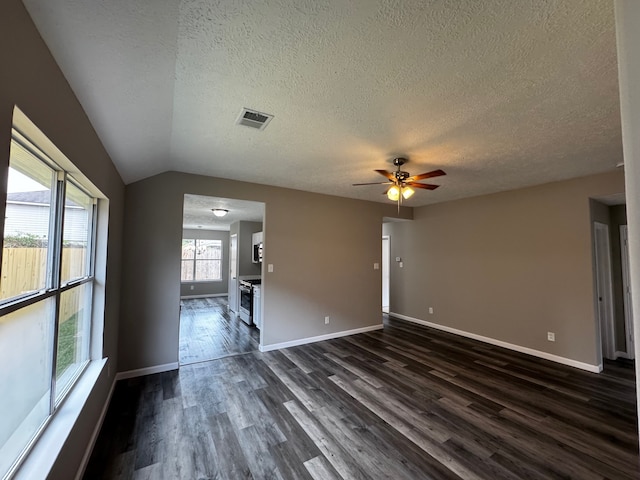 unfurnished room with a textured ceiling, vaulted ceiling, dark hardwood / wood-style floors, and ceiling fan