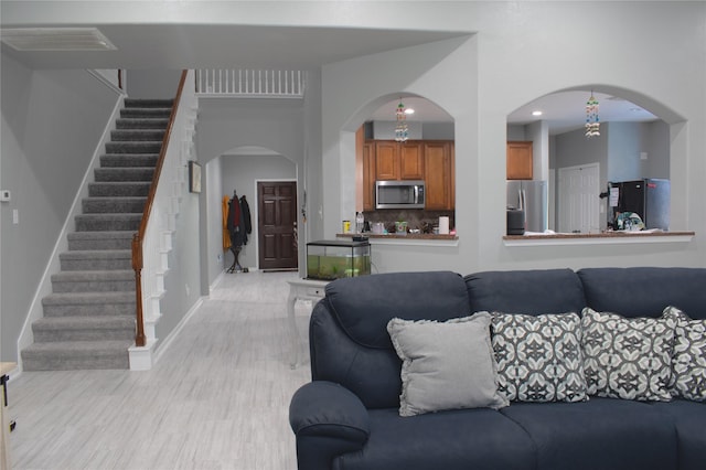 7915 Corrian Park Cir, Houston, TX 77040 - living room with baseboards, arched walkways, stairs, light wood-style floors, and recessed lighting