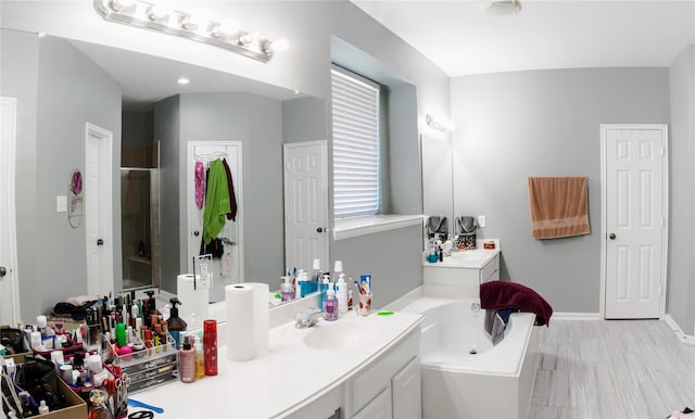 bathroom featuring vanity, plenty of natural light, and plus walk in shower