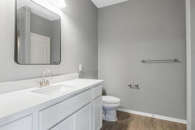 bathroom featuring hardwood / wood-style flooring, vanity, and toilet