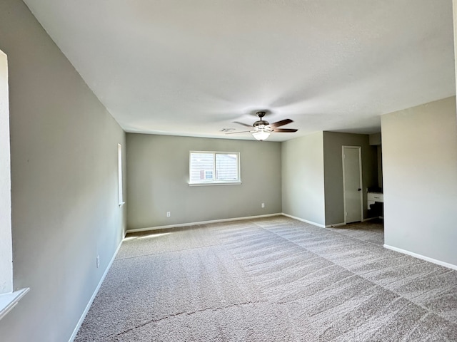 carpeted spare room with ceiling fan