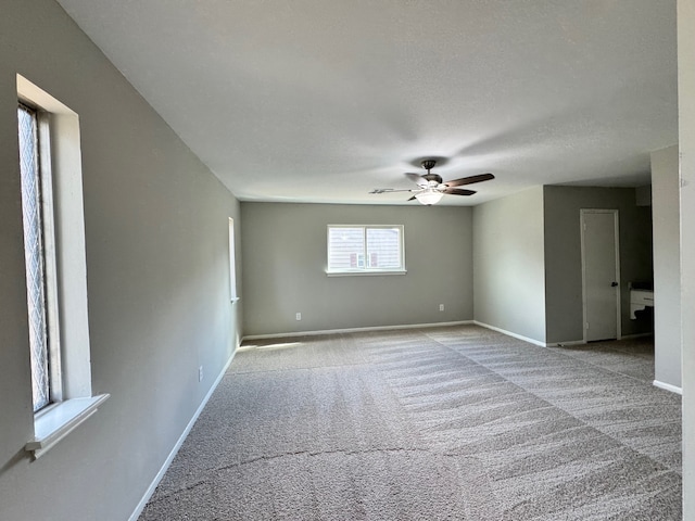 carpeted spare room featuring ceiling fan and a textured ceiling