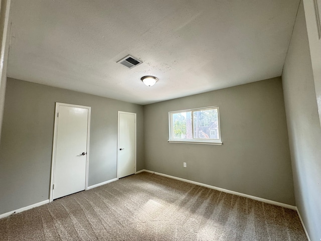 unfurnished bedroom featuring carpet and a textured ceiling