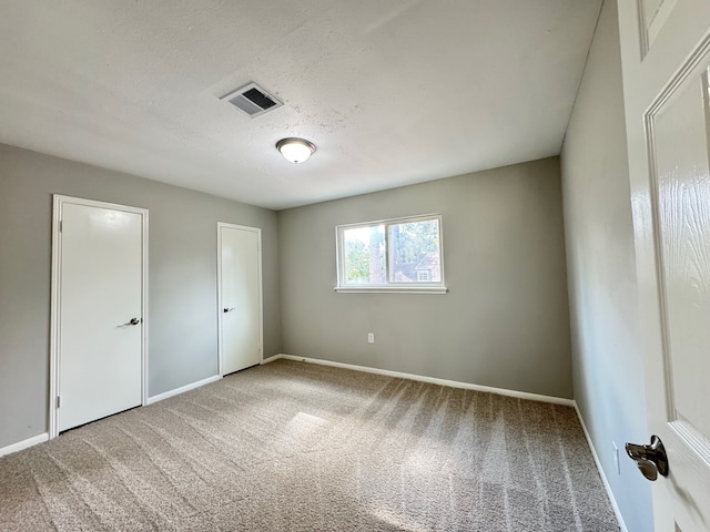 unfurnished bedroom featuring a textured ceiling and carpet floors