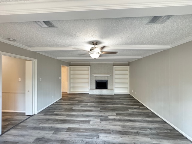 unfurnished living room with ornamental molding, dark wood-type flooring, a brick fireplace, and a textured ceiling