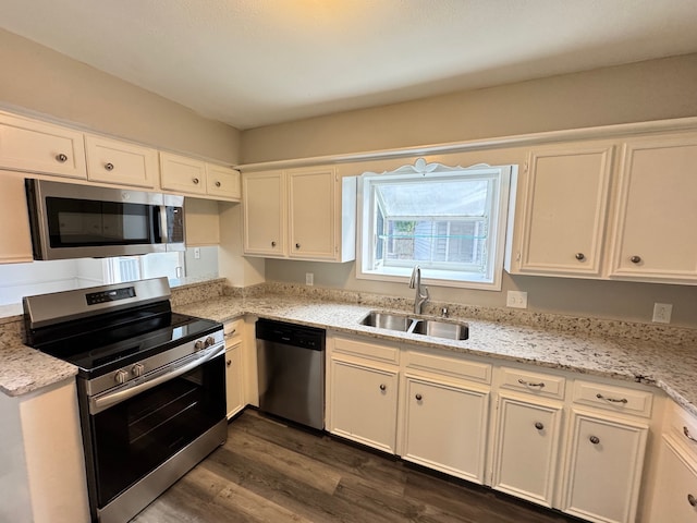 kitchen with white cabinetry, light stone countertops, dark hardwood / wood-style floors, sink, and stainless steel appliances