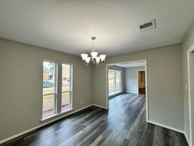 unfurnished room with dark hardwood / wood-style flooring, ornamental molding, a chandelier, and a wealth of natural light