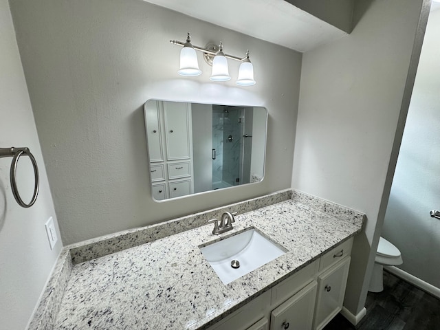 bathroom featuring vanity, toilet, and walk in shower