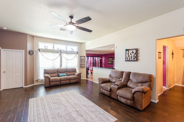 living room with dark hardwood / wood-style floors, a textured ceiling, and ceiling fan