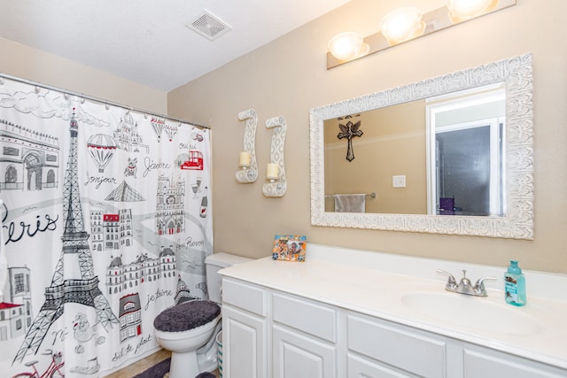 bathroom with vanity, curtained shower, and toilet