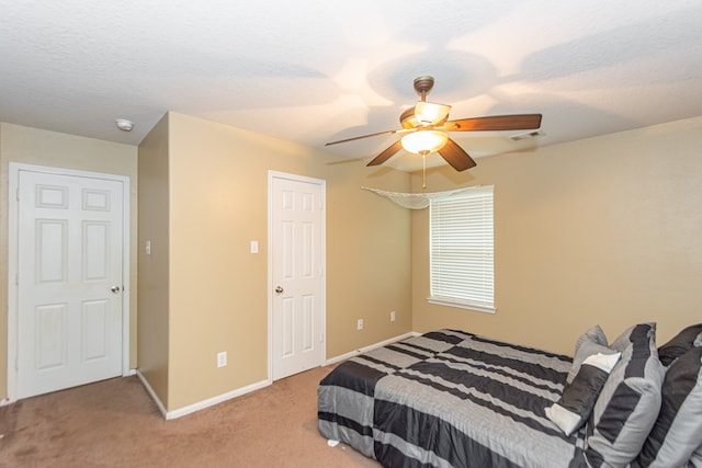 bedroom featuring ceiling fan, carpet flooring, and a textured ceiling