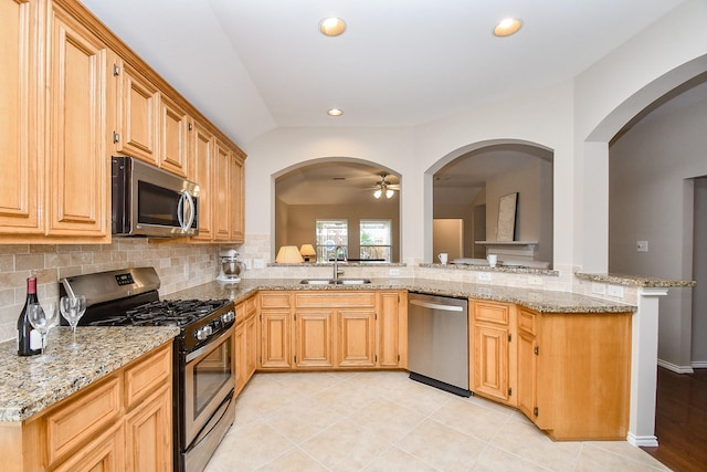 kitchen featuring light stone counters, sink, light tile patterned floors, and stainless steel appliances