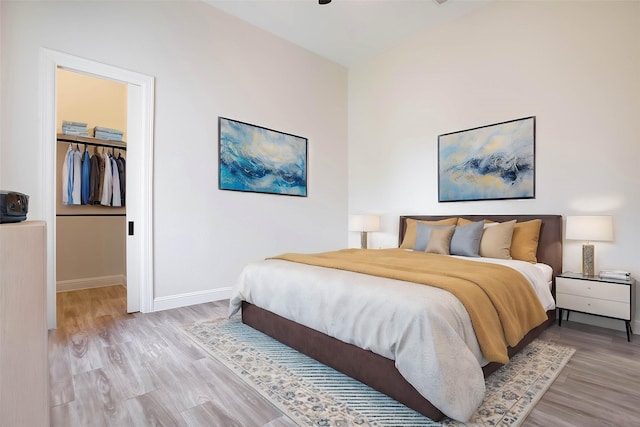 bedroom featuring light hardwood / wood-style floors, a walk in closet, and a closet