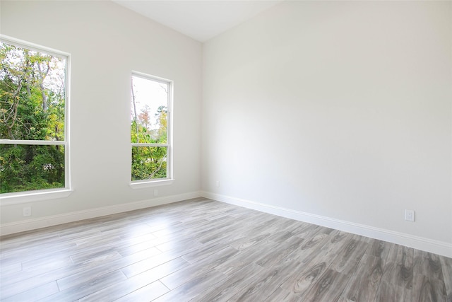 empty room with light hardwood / wood-style flooring and a healthy amount of sunlight