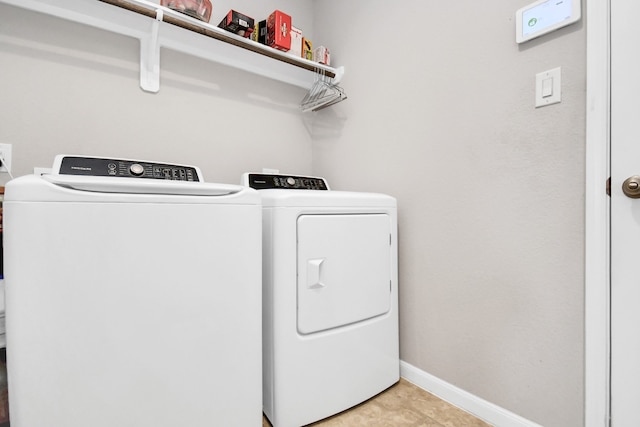 laundry room featuring light tile patterned flooring and separate washer and dryer