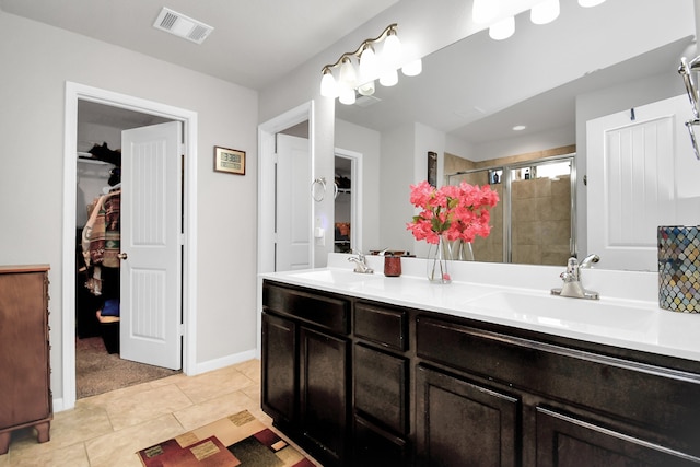 bathroom featuring vanity, a shower with shower door, and tile patterned flooring