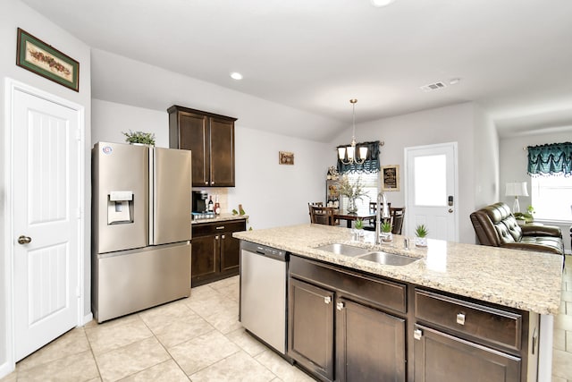 kitchen featuring dark brown cabinets, an island with sink, appliances with stainless steel finishes, a chandelier, and sink