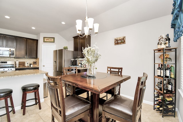 tiled dining area featuring lofted ceiling and a chandelier