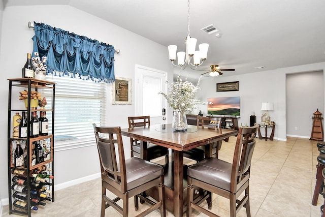 tiled dining area with lofted ceiling and ceiling fan with notable chandelier