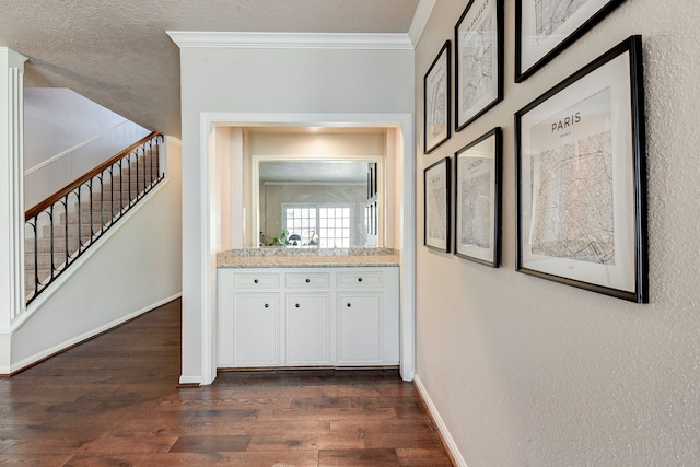 hall with crown molding, dark hardwood / wood-style floors, and a textured ceiling